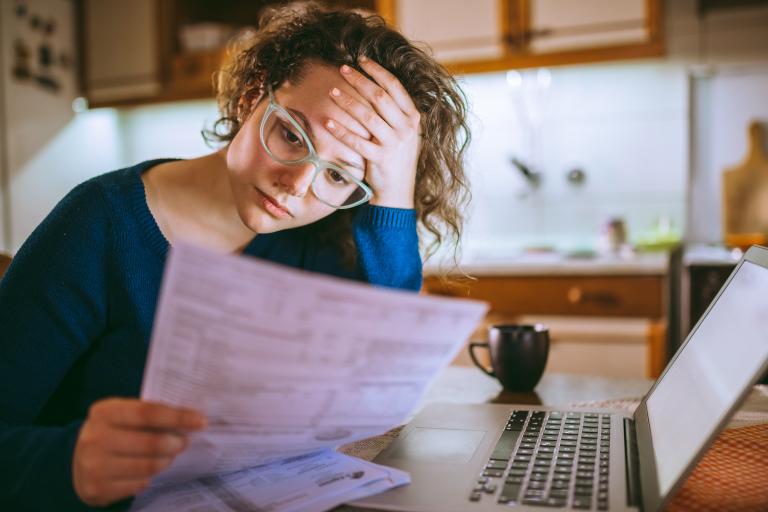 Vrouw kijkt bezorgd naar rekeningen