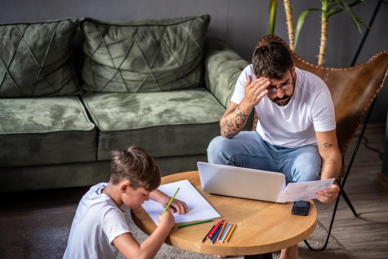 Bezorgde vader met kind in woonkamer leest brief 