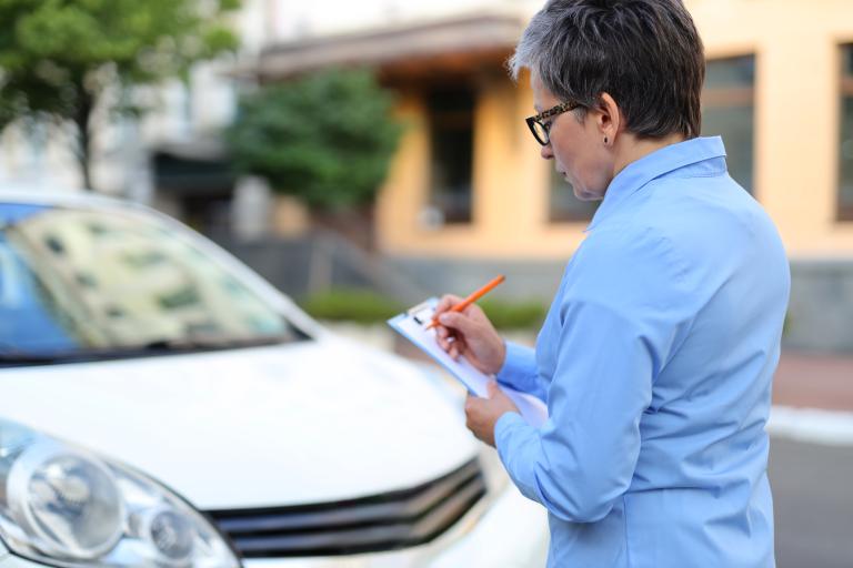 Vrouw voert op straat inspectie uit met schrijfblok in hand
